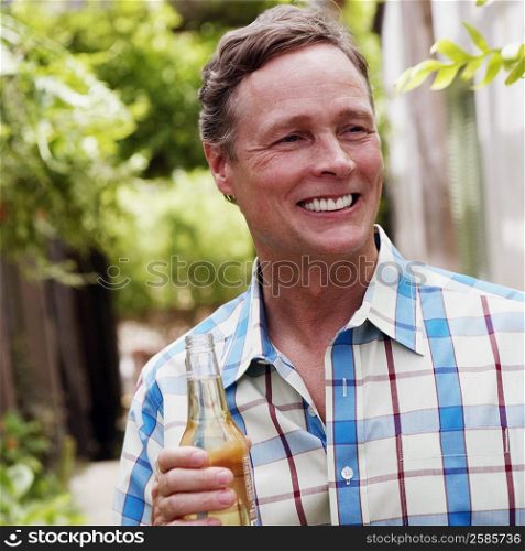 Close-up of a mature man holding a bottle of white wine