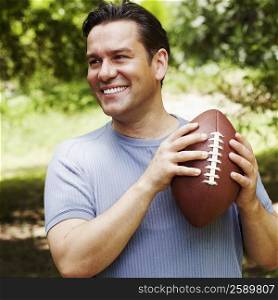 Close-up of a mature man holding a football