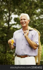 Close-up of a mature man holding a glass of juice