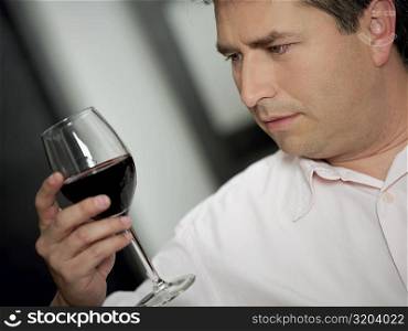 Close-up of a mature man holding a glass of wine