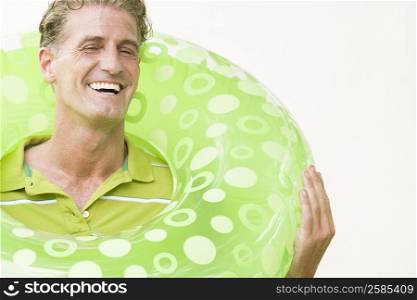 Close-up of a mature man holding an inflatable ring around his neck