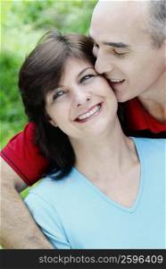 Close-up of a mature man kissing a mature woman and smiling