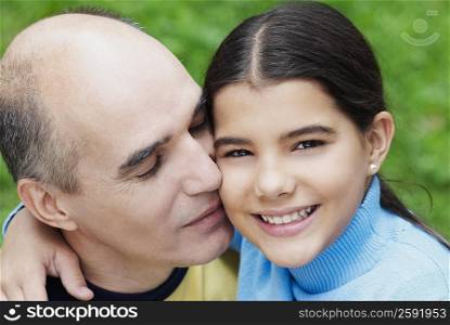 Close-up of a mature man kissing his daughter
