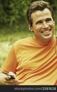 Close-up of a mature man listening to an MP3 player