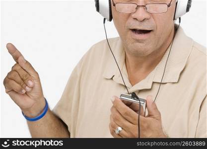 Close-up of a mature man listening to an MP3 player and singing