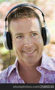 Close-up of a mature man listening to music with headphones