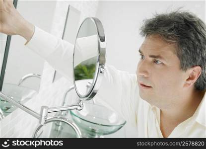 Close-up of a mature man looking at a mirror