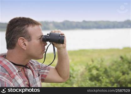 Close-up of a mature man looking through binoculars