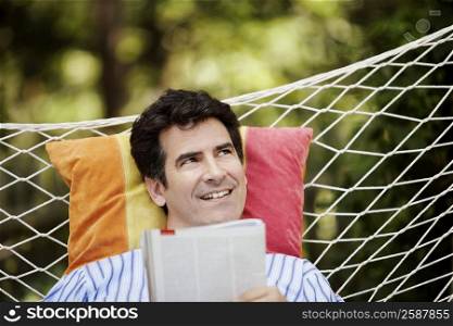 Close-up of a mature man lying in a hammock and smiling