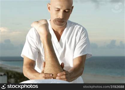 Close-up of a mature man massaging a person&acute;s leg
