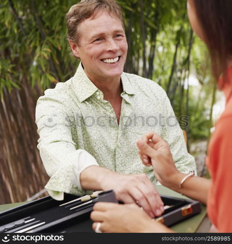 Close-up of a mature man playing backgammon with a mature woman