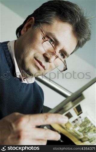Close-up of a mature man reading a magazine