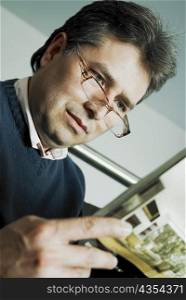 Close-up of a mature man reading a magazine