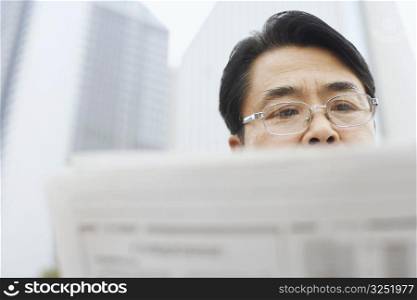 Close-up of a mature man reading a newspaper
