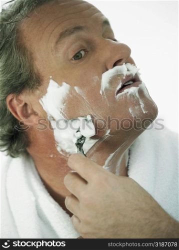 Close-up of a mature man shaving
