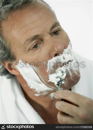 Close-up of a mature man shaving
