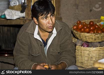 Close-up of a mature man sitting at a market stall, San Juan de Chuccho, Peru