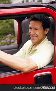 Close-up of a mature man sitting in a sports utility vehicle and smiling