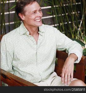 Close-up of a mature man sitting in an armchair and smiling