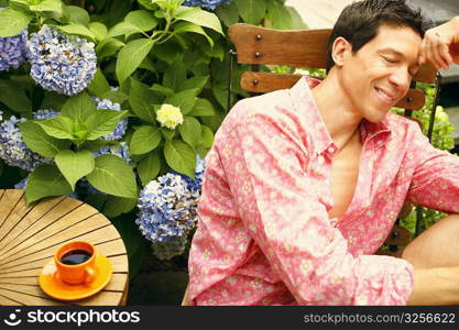 Close-up of a mature man sitting on a chair with his eyes closed