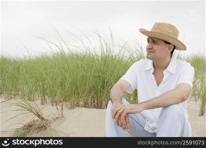 Close-up of a mature man sitting on the beach and thinking