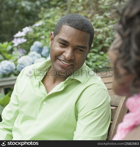 Close-up of a mature man sitting with a mid adult woman and smiling