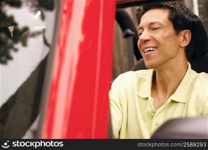 Close-up of a mature man smiling in a sports utility vehicle