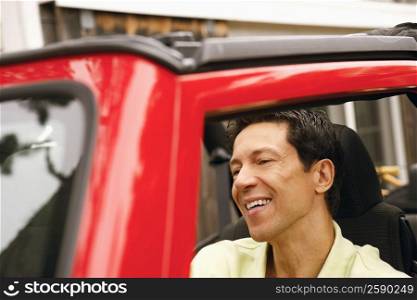 Close-up of a mature man smiling in a sports utility vehicle
