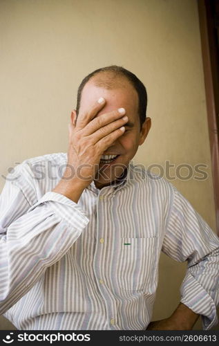 Close-up of a mature man smiling with his hand on his face