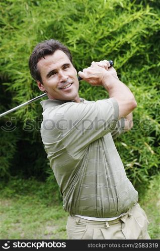 Close-up of a mature man swinging a golf club