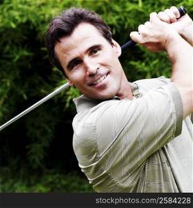 Close-up of a mature man swinging a golf club