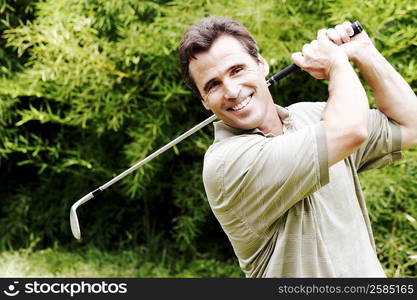 Close-up of a mature man swinging a golf club