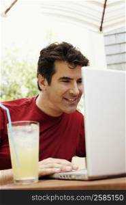 Close-up of a mature man using a laptop and smiling
