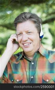Close-up of a mature man wearing headphones and listening to music