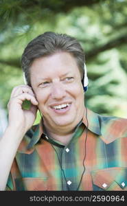 Close-up of a mature man wearing headphones and listening to music