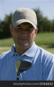 Close-up of a mature man with a golf club on a golf course