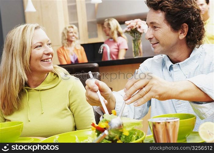 Close-up of a mature man with a mature woman sitting at the dining table