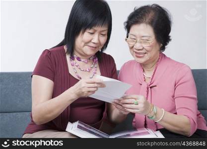 Close-up of a mature woman and a senior woman looking at photographs