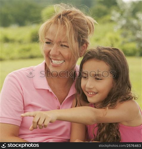 Close-up of a mature woman and her daughter pointing forwards