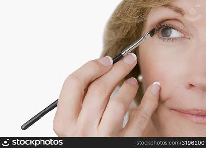 Close-up of a mature woman applying eyeliner