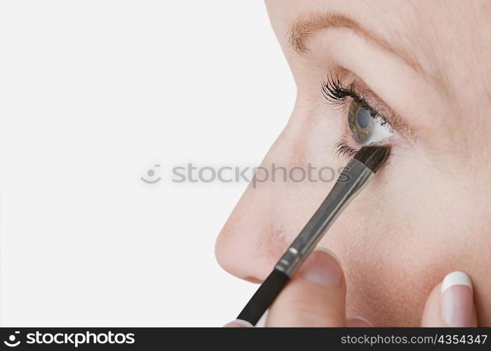 Close-up of a mature woman applying eyeliner