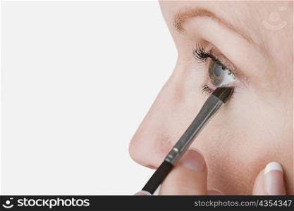 Close-up of a mature woman applying eyeliner