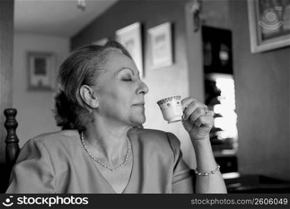 Close-up of a mature woman drinking espresso coffee
