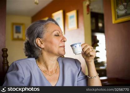 Close-up of a mature woman drinking espresso coffee