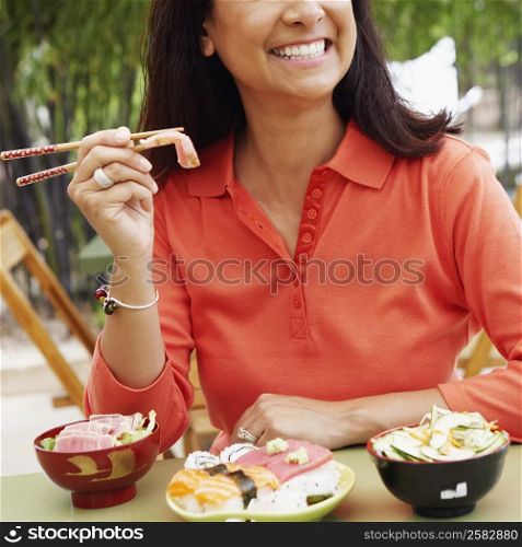 Close-up of a mature woman eating with chopsticks