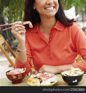 Close-up of a mature woman eating with chopsticks