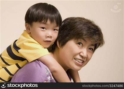 Close-up of a mature woman giving piggyback ride to her grandson