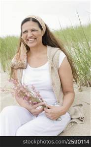 Close-up of a mature woman holding a bunch of flowers and smiling