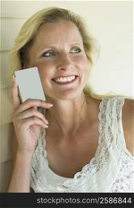Close-up of a mature woman holding a credit card and smiling