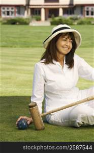 Close-up of a mature woman holding a croquet mallet and a ball